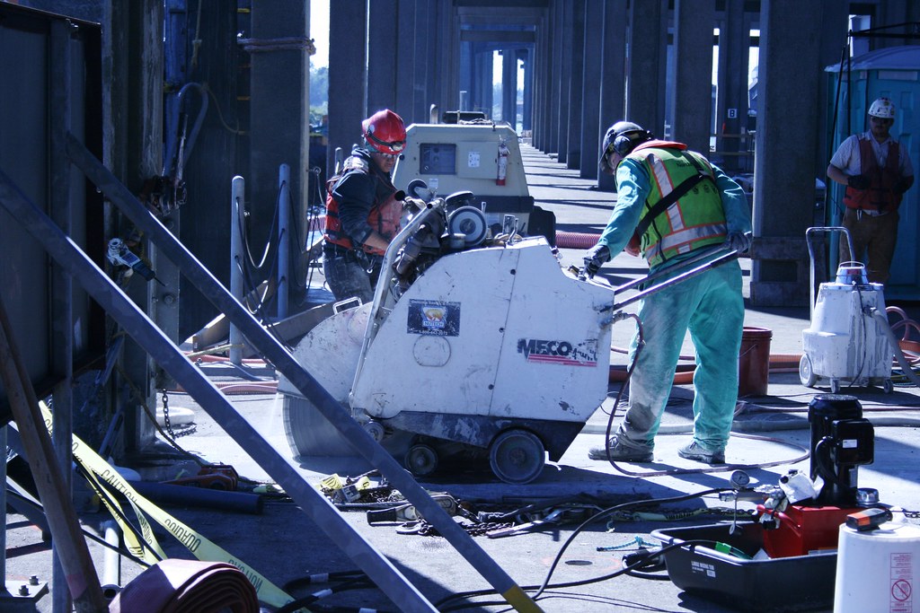 two-workers-grinding-through concrete