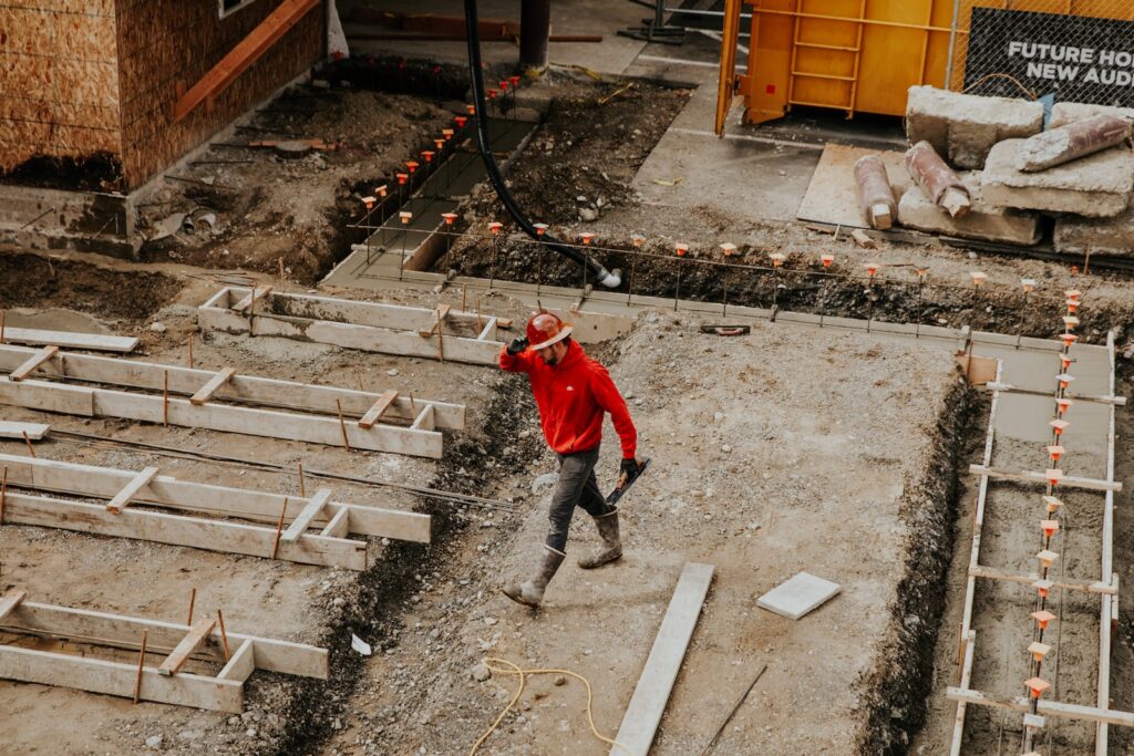 man-in-red-jacket-walking-across-concrete-floors